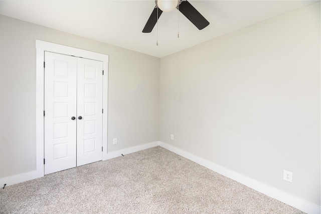 unfurnished bedroom featuring carpet flooring, a closet, baseboards, and ceiling fan
