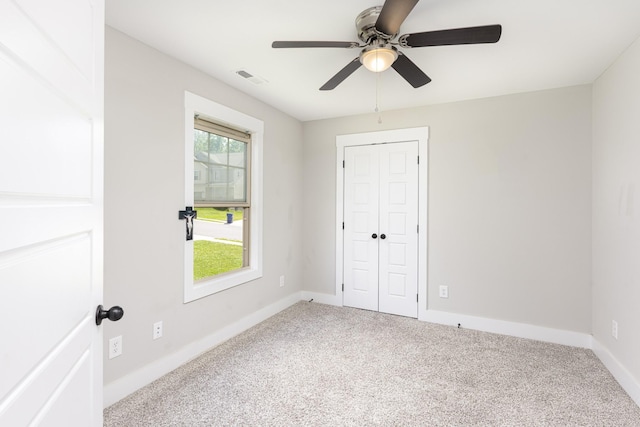 unfurnished bedroom with carpet flooring, baseboards, ceiling fan, and a closet