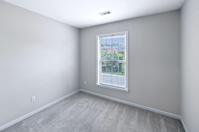 unfurnished room featuring light colored carpet and baseboards