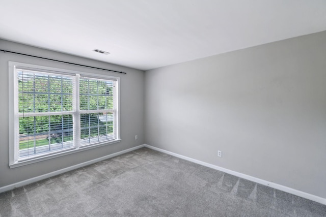 spare room with baseboards and carpet floors