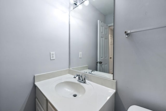 half bathroom featuring vanity and toilet