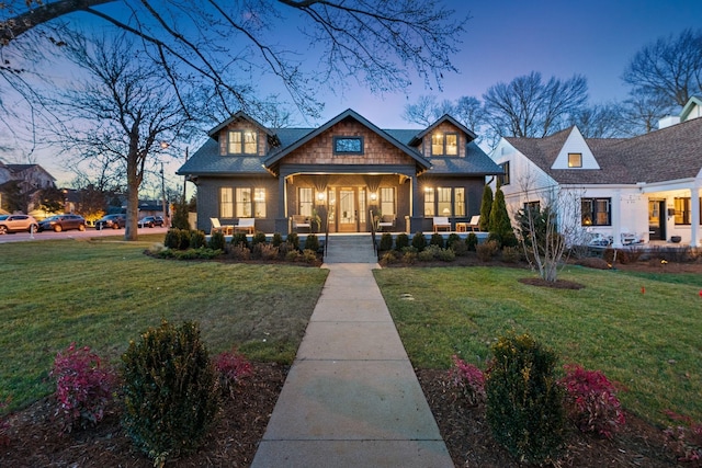 view of front of home with a porch and a yard
