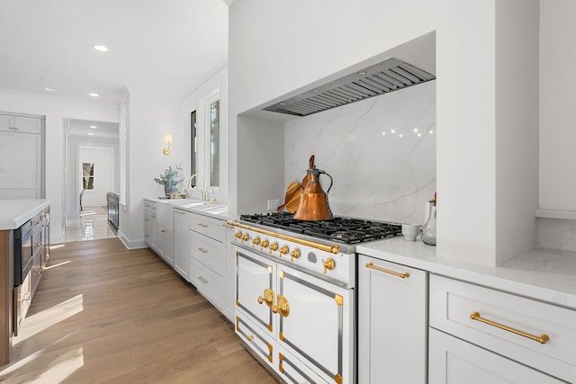 kitchen with double oven range, tasteful backsplash, light countertops, crown molding, and white cabinetry