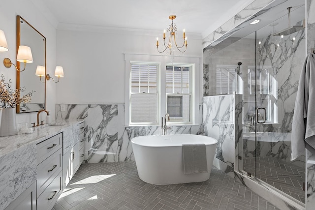 bathroom with a chandelier, a marble finish shower, vanity, tile walls, and a freestanding tub