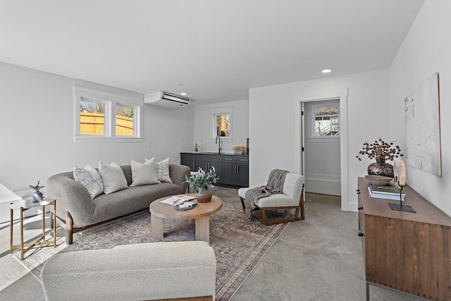 living room with a wall unit AC, healthy amount of natural light, concrete flooring, and recessed lighting