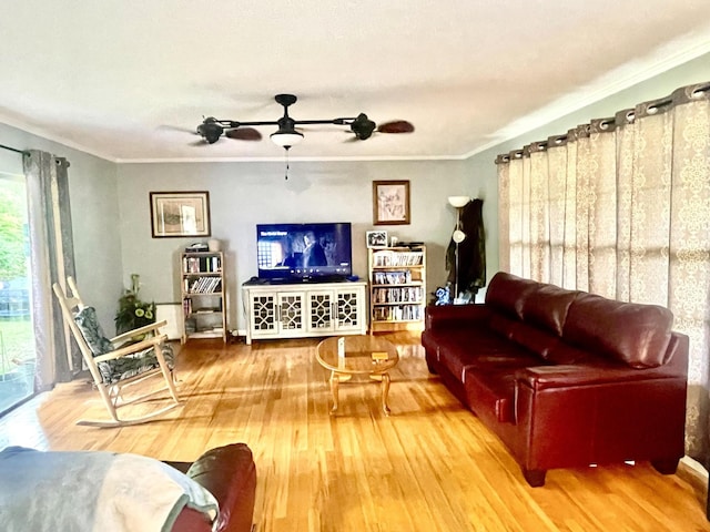 living area featuring ornamental molding, wood finished floors, and ceiling fan
