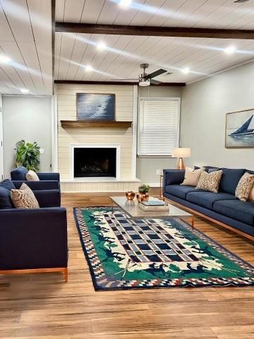 living room featuring a large fireplace, wood finished floors, wood ceiling, and beam ceiling