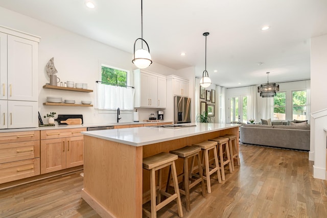 1411A Boscobel St, Nashville, TN 37206 - kitchen with stainless steel appliances, light wood-type flooring, a breakfast bar, a center island, and light countertops