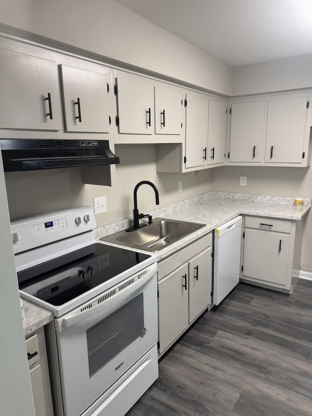 kitchen with white appliances, a sink, exhaust hood, and light countertops