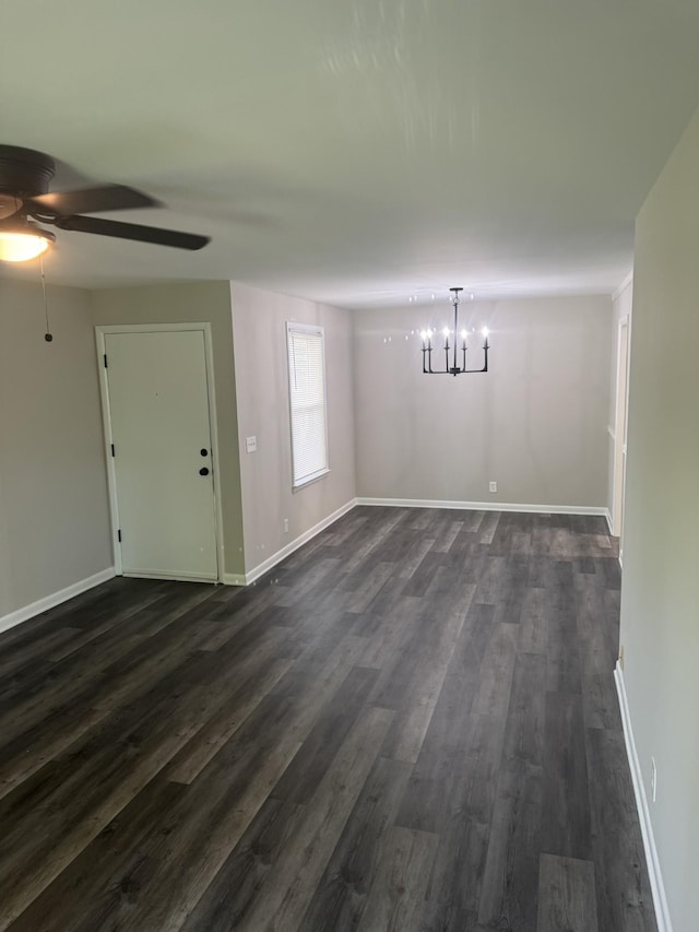 unfurnished dining area with ceiling fan, dark wood-style floors, a chandelier, and baseboards
