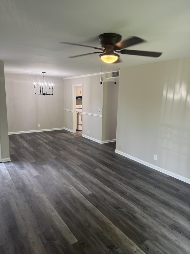 empty room featuring ceiling fan, a chandelier, dark wood finished floors, and baseboards