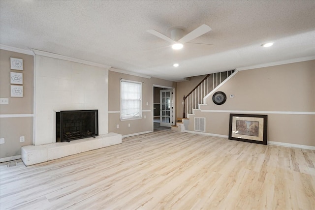 1505 Roane St, Covington, TN 38019 - unfurnished living room featuring ceiling fan, ornamental molding, a textured ceiling, a tile fireplace, and wood finished floors