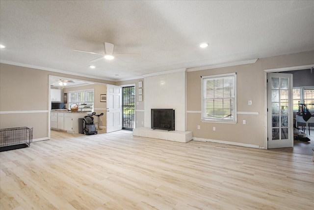 1505 Roane St, Covington, TN 38019 - unfurnished living room with ornamental molding, ceiling fan, a textured ceiling, light wood finished floors, and a fireplace with raised hearth