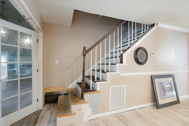 1505 Roane St, Covington, TN 38019 - stairs featuring wood finished floors, a textured ceiling, ornamental molding, and baseboards