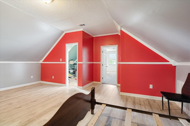 1505 Roane St, Covington, TN 38019 - bonus room featuring wood finished floors, baseboards, lofted ceiling, and a textured ceiling