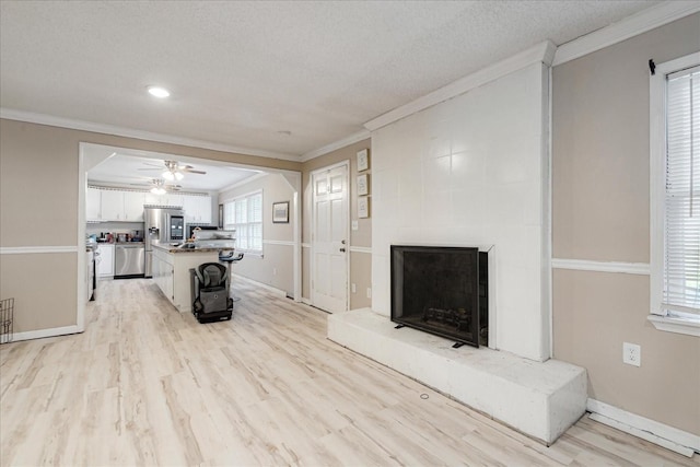 1505 Roane St, Covington, TN 38019 - living area featuring ornamental molding, a large fireplace, light wood-style flooring, ceiling fan, and baseboards