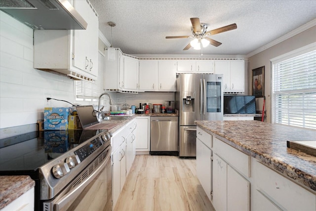 1505 Roane St, Covington, TN 38019 - kitchen featuring stainless steel appliances, under cabinet range hood, healthy amount of natural light, a sink, and a textured ceiling