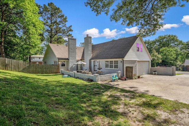 1505 Roane St, Covington, TN 38019 - rear view of property featuring a garage, concrete driveway, a chimney, and brick siding