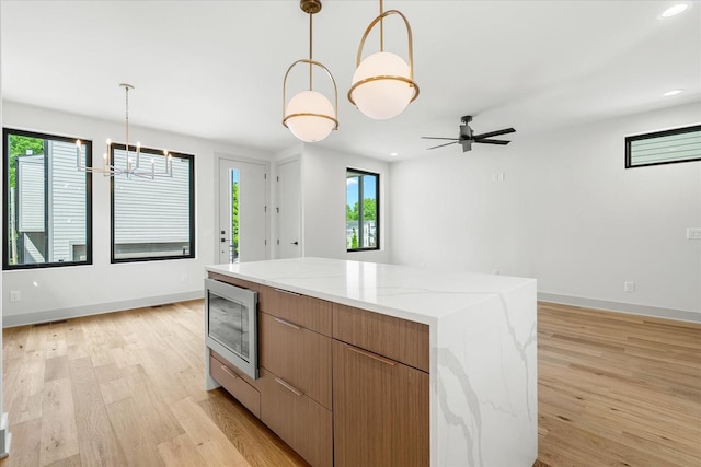 2010B 9th Ave N, Nashville, TN 37208 - kitchen with stainless steel microwave, light wood-style flooring, hanging light fixtures, baseboards, and a chandelier