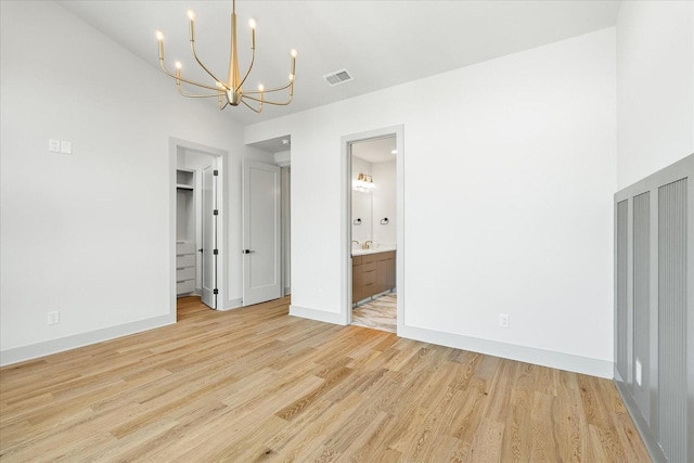 2010B 9th Ave N, Nashville, TN 37208 - unfurnished bedroom with a chandelier, light wood-type flooring, baseboards, a walk in closet, and ensuite bath