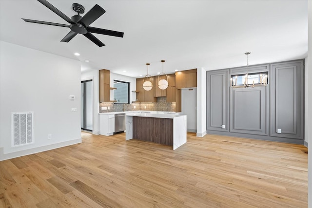2010B 9th Ave N, Nashville, TN 37208 - kitchen featuring stainless steel dishwasher, light countertops, a chandelier, light wood-style flooring, and a center island