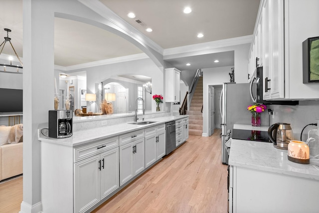1113 Chickadee Cir, Hermitage, TN 37076 - kitchen featuring stainless steel appliances, a sink, arched walkways, ornamental molding, and white cabinets