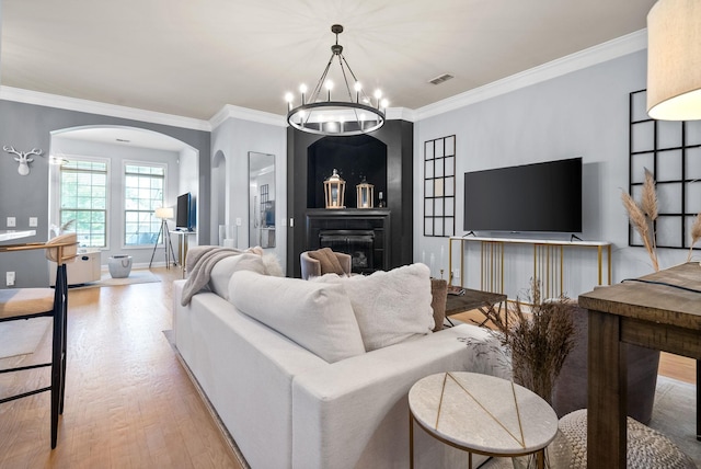 1113 Chickadee Cir, Hermitage, TN 37076 - living room with arched walkways, light wood-style floors, ornamental molding, a chandelier, and a fireplace