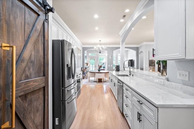 1113 Chickadee Cir, Hermitage, TN 37076 - kitchen with appliances with stainless steel finishes, a sink, arched walkways, ornamental molding, and white cabinetry