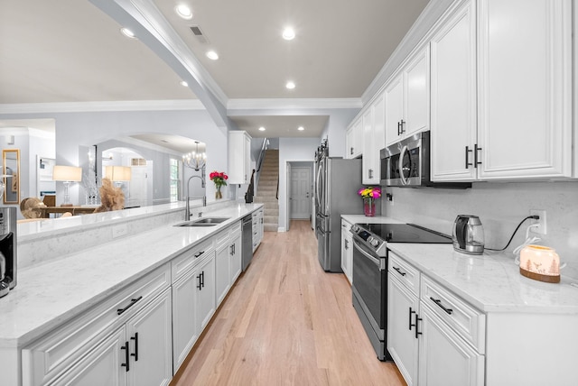 1113 Chickadee Cir, Hermitage, TN 37076 - kitchen with stainless steel appliances, a sink, ornamental molding, white cabinetry, and arched walkways