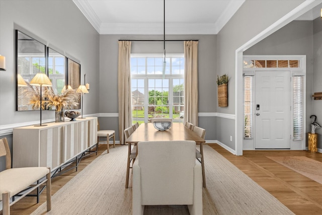 dining area with ornamental molding, baseboards, and wood finished floors