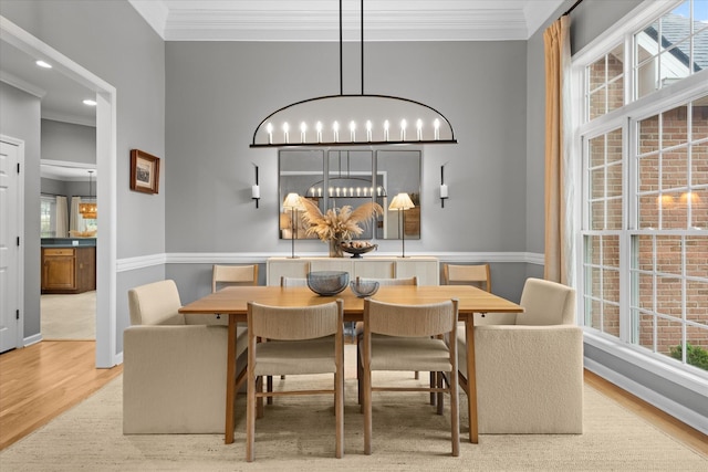 dining room featuring a chandelier, wood finished floors, ornamental molding, healthy amount of natural light, and recessed lighting