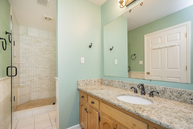 full bath with a shower stall, vanity, and tile patterned floors