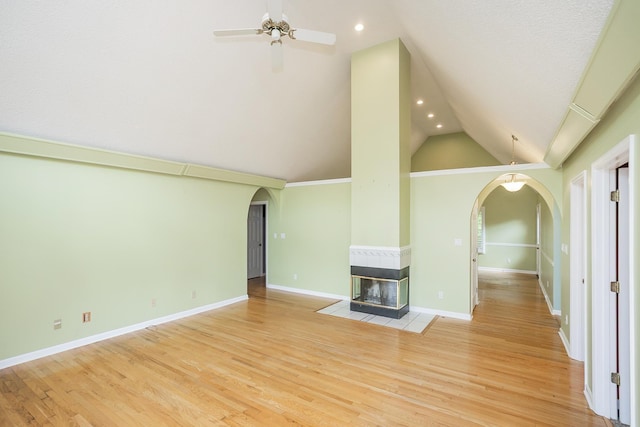 unfurnished living room featuring arched walkways, a ceiling fan, recessed lighting, light wood-style flooring, and a multi sided fireplace