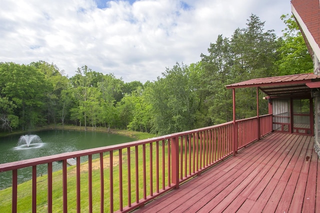 deck featuring a water view, a lawn, and a view of trees