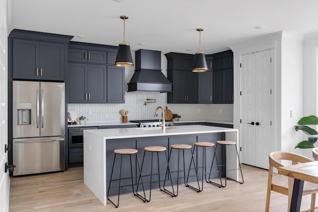 603B Freedom Ct, Nashville, TN 37209 - kitchen with stainless steel fridge with ice dispenser, premium range hood, light countertops, light wood-style flooring, and recessed lighting