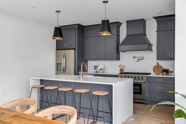 603B Freedom Ct, Nashville, TN 37209 - kitchen with appliances with stainless steel finishes, premium range hood, a sink, a breakfast bar area, and light countertops