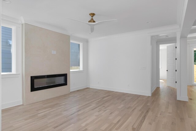 6401 Thunderbird Dr, Nashville, TN 37209 - unfurnished living room featuring a large fireplace, light wood finished floors, ceiling fan, plenty of natural light, and crown molding