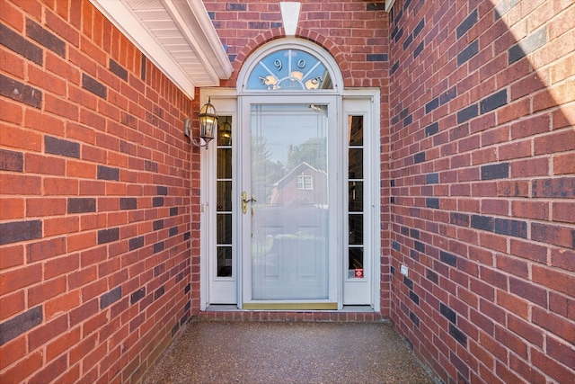 entrance to property featuring brick siding