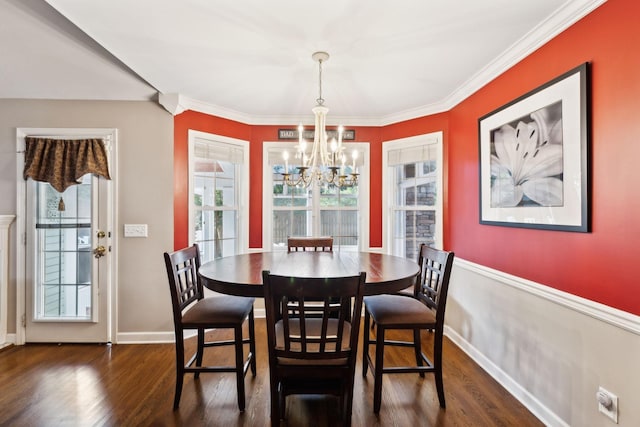 dining area featuring a chandelier, wood finished floors, crown molding, and baseboards