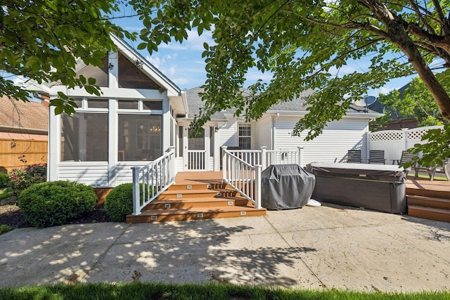 back of house featuring a hot tub, a sunroom, a patio area, fence, and roof with shingles