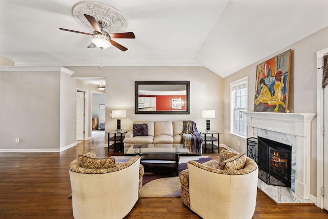 living room featuring ceiling fan, a premium fireplace, baseboards, and dark wood-style flooring