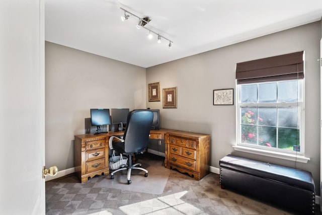 office space with rail lighting, carpet flooring, plenty of natural light, and baseboards