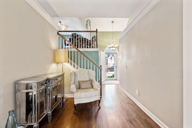 sitting room featuring baseboards, wood finished floors, stairway, and a chandelier