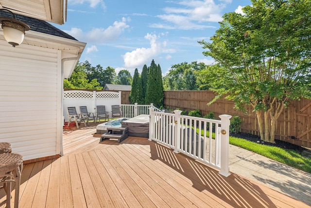 wooden deck with a fenced backyard and an outdoor fire pit