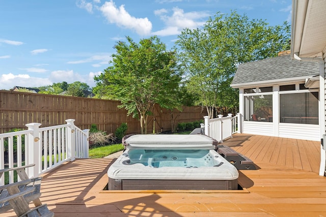wooden terrace with a covered hot tub, a fenced backyard, and a sunroom