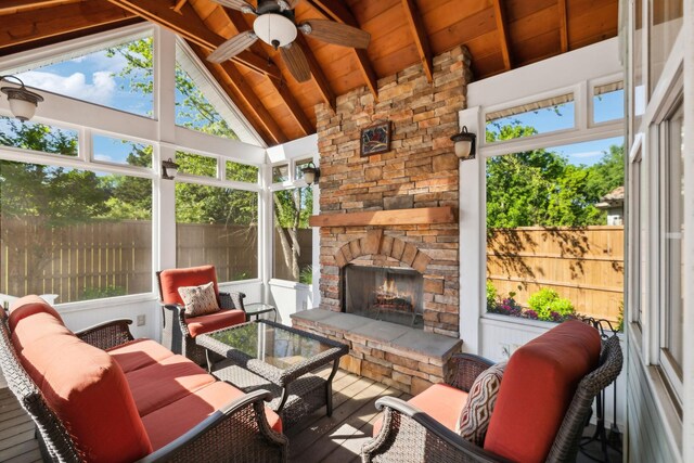 sunroom featuring an outdoor living space with a fireplace, ceiling fan, and plenty of natural light