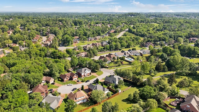 aerial perspective of suburban area featuring a heavily wooded area
