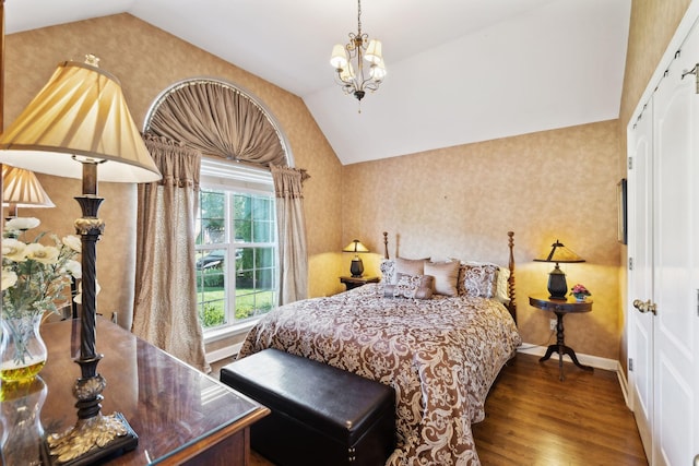 bedroom with vaulted ceiling, wood finished floors, a chandelier, baseboards, and wallpapered walls