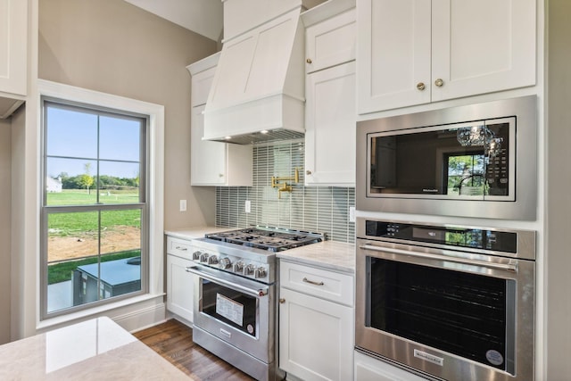 1611 Martha Washington Way, Murfreesboro, TN 37130 - kitchen featuring appliances with stainless steel finishes, premium range hood, decorative backsplash, white cabinets, and light stone countertops