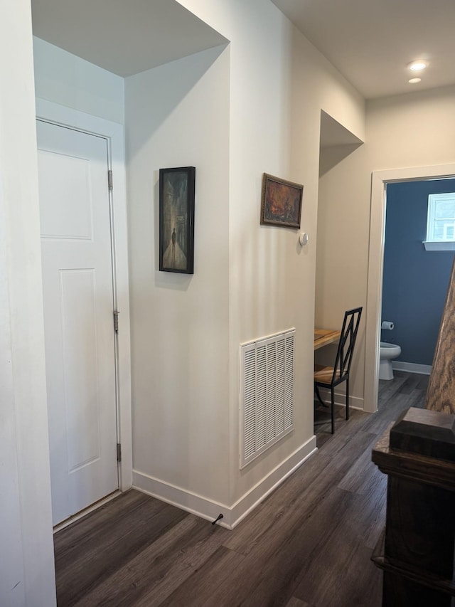 hallway featuring dark wood-style floors and baseboards